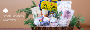 A large woven basket, filled with colorful items from western Washington small businesses and decorative coniferous foliage, with a white Girl Scout trefoil and text that says, “Small Business Giveaway” at the side with a warm-colored backdrop.
