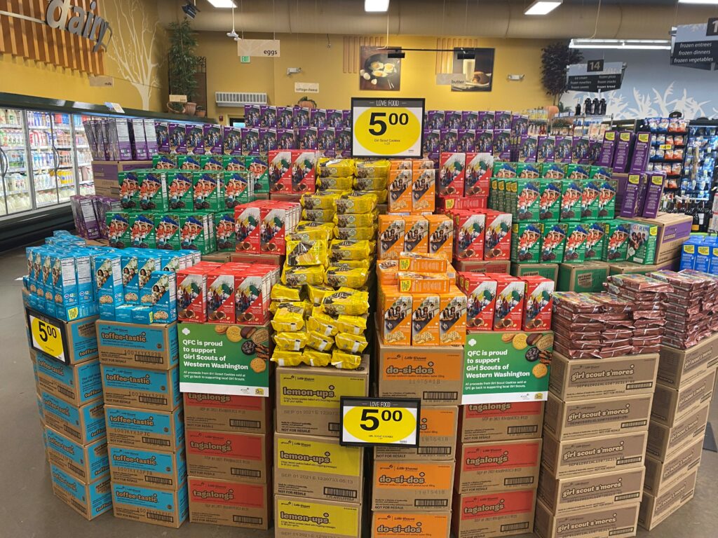 Display of Girl Scout Cookie boxes in a grocery store.