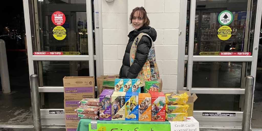 Girl Scout behind their cookie booth