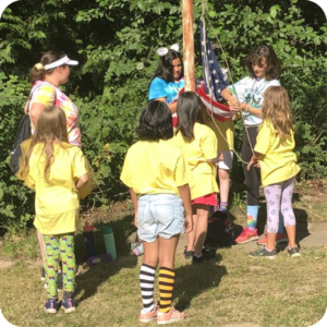 Girl Scouts surrounding flag pole attacking an American flag